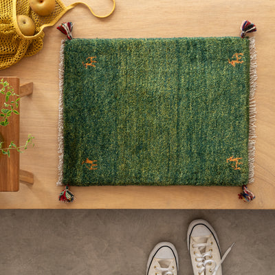 グリーンのペルシャ手織りギャッベ絨毯。ナチュラルなインテリアと植物がある玄関をよりおしゃれにしてくれる玄関マット。ギャッベのミニサイズは小さめのサイズなので、狭い玄関にぴったりです。